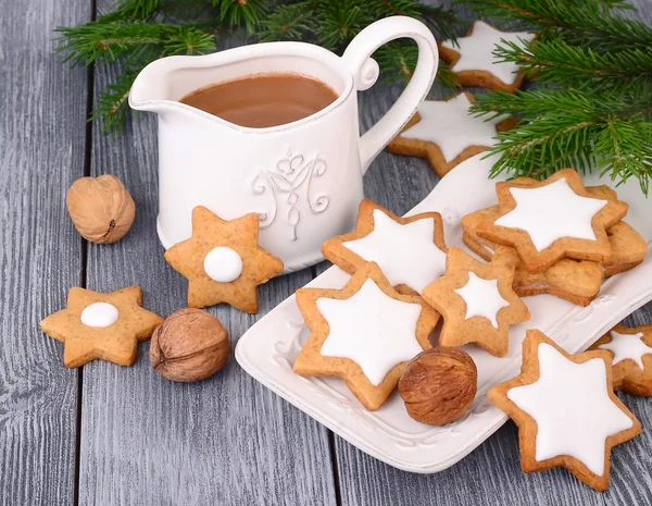 Gingersnap de Navidad en forma de asteriscos y chocolate caliente sobre un fondo de madera gris. Un fondo navideño con el lugar para el texto . —  Fotos de Stock