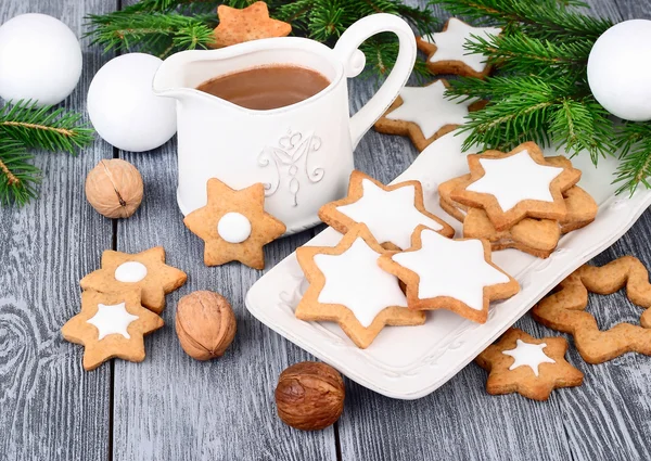 Kerst gingersnap in de vorm van sterretjes en warme chocolademelk op een houten grijze achtergrond. Een Kerstmis achtergrond met de plaats van de tekst. Stockfoto