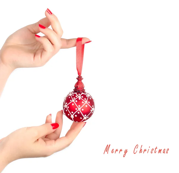 Esfera roja de Navidad sobre una mano femenina sobre un fondo blanco. Un fondo navideño con espacio para el texto . — Foto de Stock