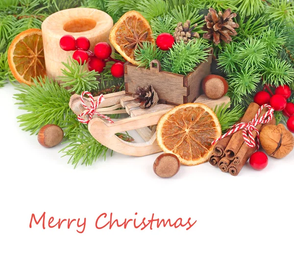 O trenó decorativo, o cone e a decoração de Natal em ramos de uma árvore de Natal em um contexto branco. Um fundo de Natal com espaço para o texto . — Fotografia de Stock