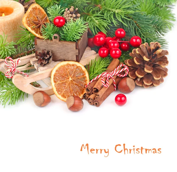 El trineo decorativo, el cono y la decoración navideña sobre las ramas del árbol de Navidad sobre el fondo blanco. Un fondo navideño con espacio para el texto . — Foto de Stock