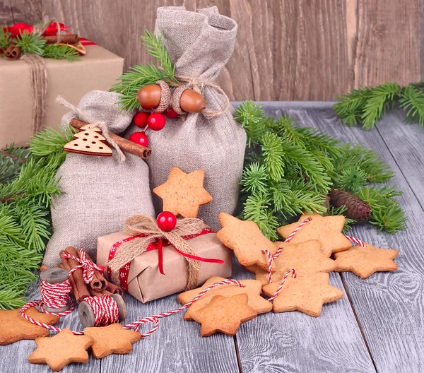 Christmas gifts and gingersnap in the form of stars on a string on a gray wooden background. A Christmas background with space for the text. — Stock Photo, Image