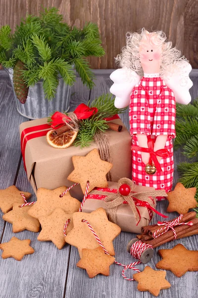 Kerst gingersnap op een tekenreeks en een kerst engel op een grijze houten achtergrond. Rechtenvrije Stockafbeeldingen