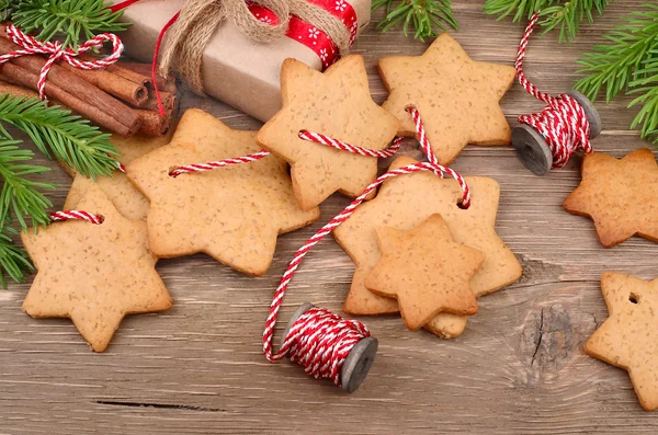 Gingersnap de Navidad en una cuerda y una caja de regalo sobre un fondo de madera gris . —  Fotos de Stock