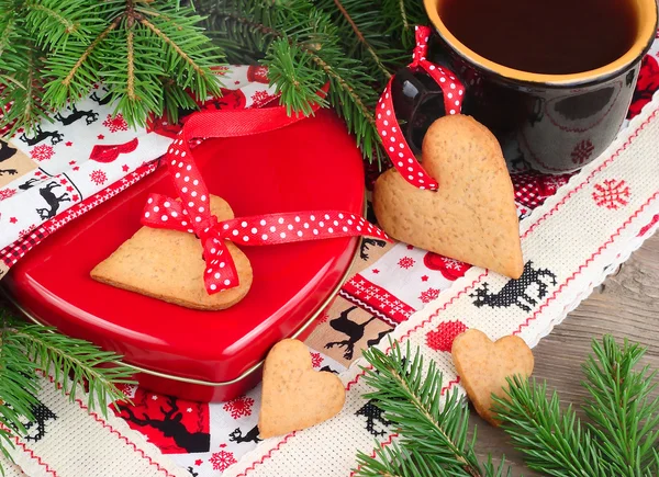 圣诞 gingersnap 和杯茶在绣布上木制的背景. 图库图片