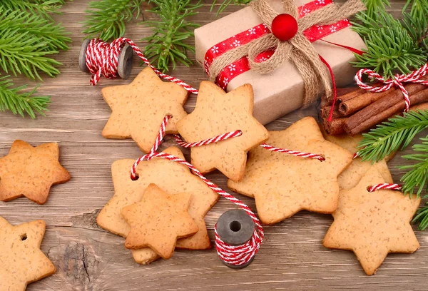 Noel gingersnap bir dize ve bir hediye kutusu gri bir ahşap zemin üzerine. — Stok fotoğraf