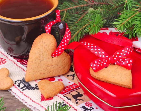 Natal gingersnap e xícara de chá no pano de Natal bordado em um fundo de madeira . — Fotografia de Stock