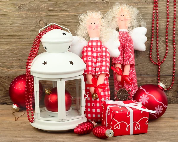 Red Christmas angels, kerstballen en een klein lampje op een houten achtergrond. Een Kerstmis achtergrond met ruimte voor de tekst. Rechtenvrije Stockafbeeldingen