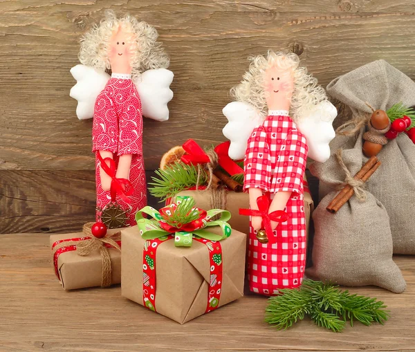 Rode Kerst engelen en geschenkdozen op een houten achtergrond. Een Kerstmis achtergrond met ruimte voor de tekst. Stockfoto