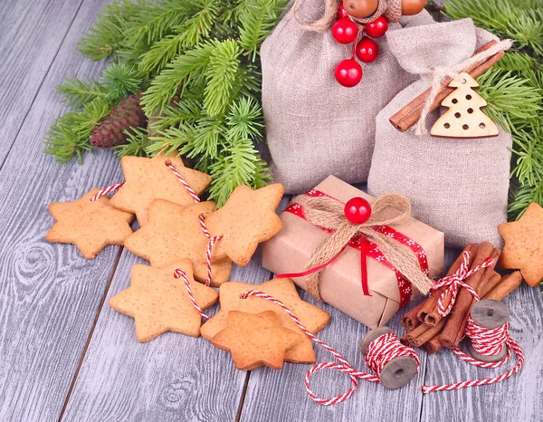 Regali di Natale e pan di zenzero nella forma di stelle su una stringa su uno sfondo grigio di legno. Uno sfondo natalizio con spazio per il testo . — Foto Stock