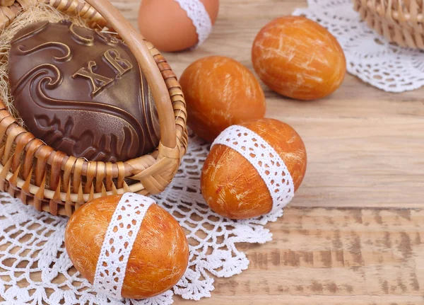 Œuf de Pâques en chocolat dans un panier sur un fond en bois. Un fond de Pâques avec espace pour le texte . — Photo