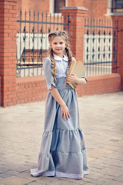 Κορίτσι Μαθήτρια Ρετρό Φόρεμα Κρατά Ένα Βιβλίο Στα Χέρια Της — Φωτογραφία Αρχείου