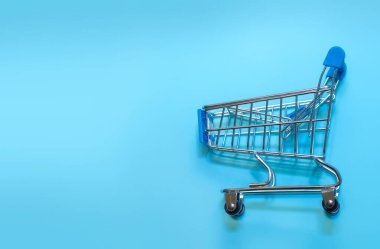 Mavi arka planda boş bir alışveriş sepeti. Çevrimiçi alışveriş konsepti. ? opy boşluk, üst görünüm