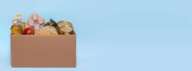 Bağış kutusunda yiyecek, mavi arka planda izole edilmiş, kopyalama alanı. Coronavirus Yardım Fonları ve Bağış. Bağış. Gıda Bankasına Bağış Yapıyor.
