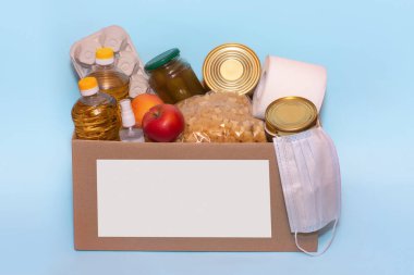 Bağış kutusunda yiyecek, mavi arka planda izole edilmiş, kopyalama alanı. Coronavirus Yardım Fonları ve Bağış. Bağış. Gıda Bankasına Bağış Yapıyor