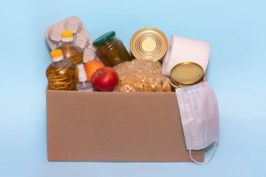 Bağış kutusunda yiyecek, mavi arka planda izole edilmiş, kopyalama alanı. Coronavirus Yardım Fonları ve Bağış. Bağış. Gıda Bankasına Bağış Yapıyor