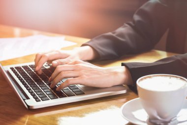 yumuşak odak kadın el sabah ışık ofisinde ahşap masa telefonu ve laptop çalışma. Vintage etkisi