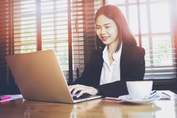 Soft Focus Sea... van vrouw hand werkende laptop op houten balie in kantoor in ochtend licht. Vintage effect. — Stockfoto