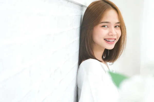Cópia espaço retrato de sorrindo asiático jovem mulher colocar no aparelho, no fundo branco — Fotografia de Stock