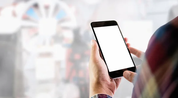 El hombre de una camisa a cuadros roja sostiene una pantalla en blanco de un teléfono inteligente en el fondo de tomar un artículo de la línea de estudio. Tome su pantalla para poner en la publicidad . — Foto de Stock