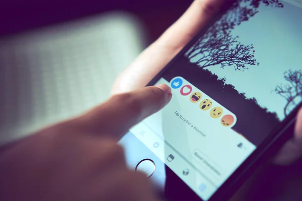 Bangkok, Thailand - August 22, 2017 :  hand is pressing the Facebook screen on apple iphone6 ,Social media are using for information sharing and networking. — Stock Photo, Image