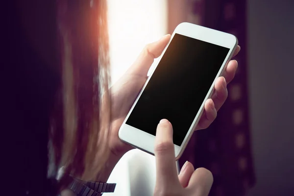 Woman holding a white phone with a black screen. vintage effect. — Stock Photo, Image