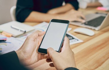 Adam telefon ofis ahşap masa üzerinde tutar. Üyeleri şu anda buluşuyoruz. Teknolojik kavramları ilerleme.