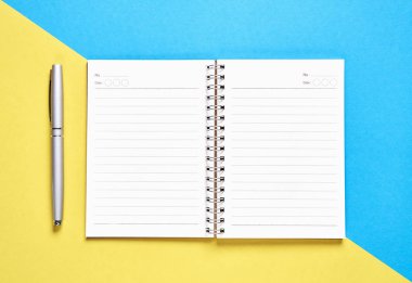 Siyah ekran boş defter ve kalem pastel sarı ve mavi zemin üzerine yerleştirilir. Reklam için kullanılan grafik için uygundur..