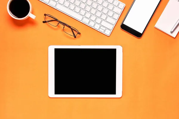 Vista superior, lugar de trabajo moderno con ordenador portátil y tableta con teléfono inteligente colocado sobre un fondo amarillo pastel. Espacio de copia adecuado para su uso en gráficos . — Foto de Stock