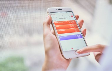 Bangkok, Tayland - 12 Kasım 2017: smartphone iphone 6 sağlık app ekranda tutan kadın. IOS 11 hangi kullanıcının fitness verileri izlemek için bir uygulamadır.