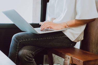 Kadın kahve dükkanında çalışmaya bir bilgisayar kullanıyorsunuz. Her yerde modern teknoloji ile çalışma kavramı.