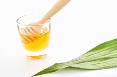 Tatlım cam ve kaşık kolay karıştırma için yuvarlak şekli var. Beyaz arka plan üzerinde mockup için. Doğal güzellik ürünleri kavramı.