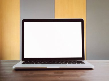 Belgili tanımlık laptop kahverengi ahşap masa üzerinde boş bir beyaz ekran açın. Arka planda sarı ve gri dönüşümlü olarak güzel olduğunu. Grafik şablonu koymak için kullanılan.