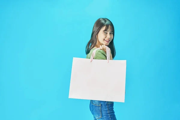 Frau Grünen Hemden Mit Einkaufstüten Blauen Hintergrund — Stockfoto