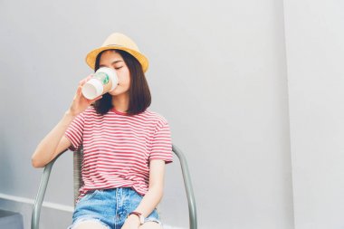 Bangkok, Tayland - 21 Şubat 2018: Kadın, sandalyenin üstünde Starbucks kahve içme Starbucks marka kahve hizmet dünya çapında lider biridir.