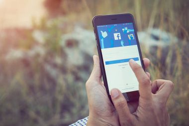 Bangkok, Tayland - 26 Şubat 2018: kadın el Facebook ekranı apple iphone6 çayır üzerinde üzerinde baskı yapıyor, sosyal medya paylaşım ve ağ bilgi için kullanıyorsanız.