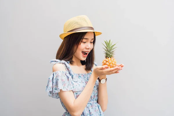 年轻的女孩开心的笑着 穿着蓝色的连衣裙 手里拿着两个菠萝 概念暑期旅游 — 图库照片