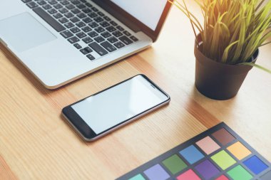 Smartphone ve dizüstü bilgisayarda office odası, grafik tabloda montaj görüntüler. Senin ekran reklam koymak için almak.