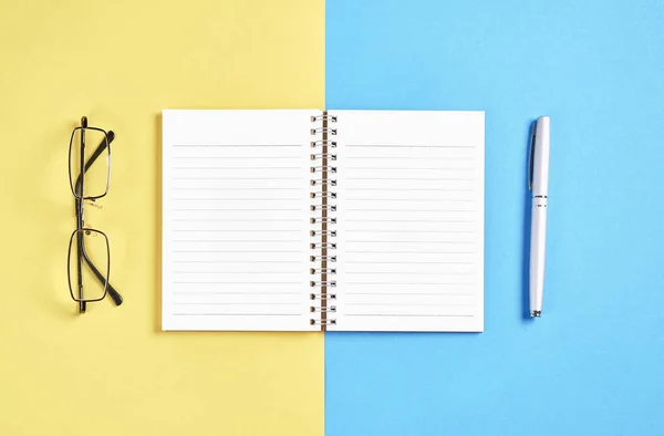 Caderno Tela Preta Branco Caneta Colocada Fundo Amarelo Azul Pastel — Fotografia de Stock