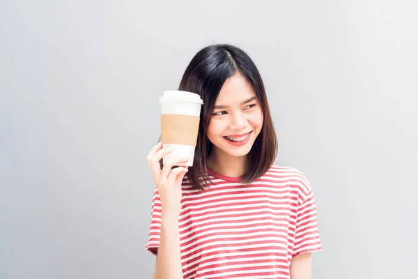 年轻女孩快乐的笑容和欢快的红色礼服拿着一个白色的咖啡杯在手 概念暑期旅游 — 图库照片
