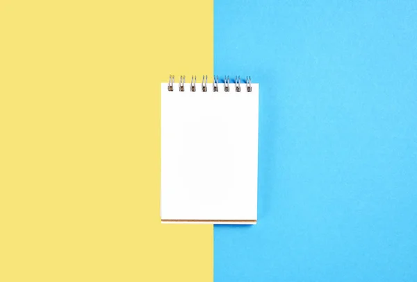 Caderno Tela Preta Branco Caneta Colocada Fundo Amarelo Azul Pastel — Fotografia de Stock