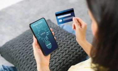 Akıllı telefon ve kredi kartı tutan kadının biyometrik parmak izi taraması uygulamalı cüzdanda ödemeli cep telefonu bankacılığına giriş izni için yapılıyor.. 