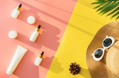 Beyaz şişe kremi, güzellik ürünleri markasının maketi. Pembe ve sarı arkaplanda üst manzara. yaz konsepti