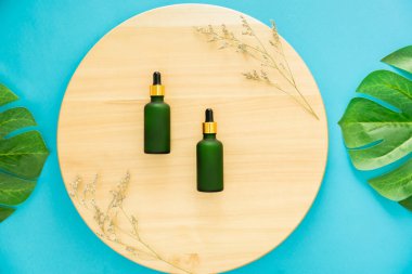 Yeşil ilaç şişesi, ürün markasının maketi. Mavi arkaplanda üst görünüm.