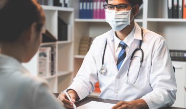 Yakın doktor hastaların belirtileri açıklamak, Sağlık ve tıbbi. ve hasta oturma dinlemek ve stres gösteren.