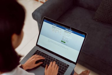 Bangkok, Tayland - 20 Mart 2020: Kadın eli Apple Macbook Pro 'da Facebook ekranına basıyor, sosyal medya bilgi paylaşımı ve ağ paylaşımı için kullanıyor.