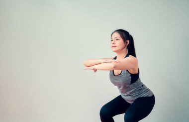 Spor kıyafetleri giyen ve oturma odasında yoga yapan Asyalı bir kadın. Sağlıklı yaşam tarzı kavramı.