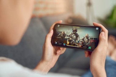 Bangkok, Tayland - 20 Mart 2020: Akıllı telefonu tutmak ve cep telefonuyla oyun oynamak.