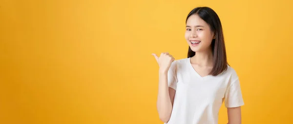 Sonriente Mujer Asiática Pie Señalando Dedo Sobre Fondo Naranja — Foto de Stock