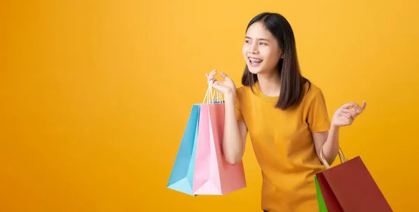 Joven Mujer Asiática Sonriente Sosteniendo Bolsas Compras Multicolores Mirando Sobre —  Fotos de Stock